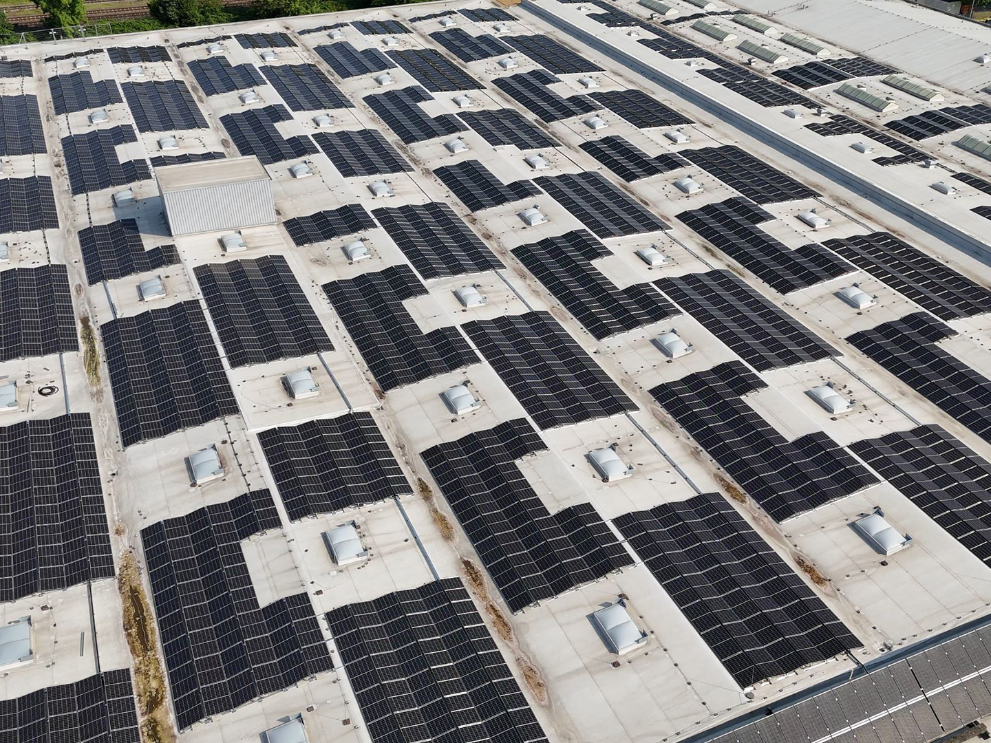Vogelperspektive auf ein Dach, das vollständig mit Solarpaneelen bedeckt ist